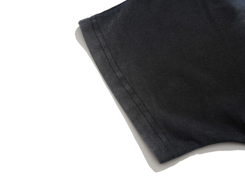 Close-up of black gothic graphic tee sleeve hem with visible stitching and soft cotton texture