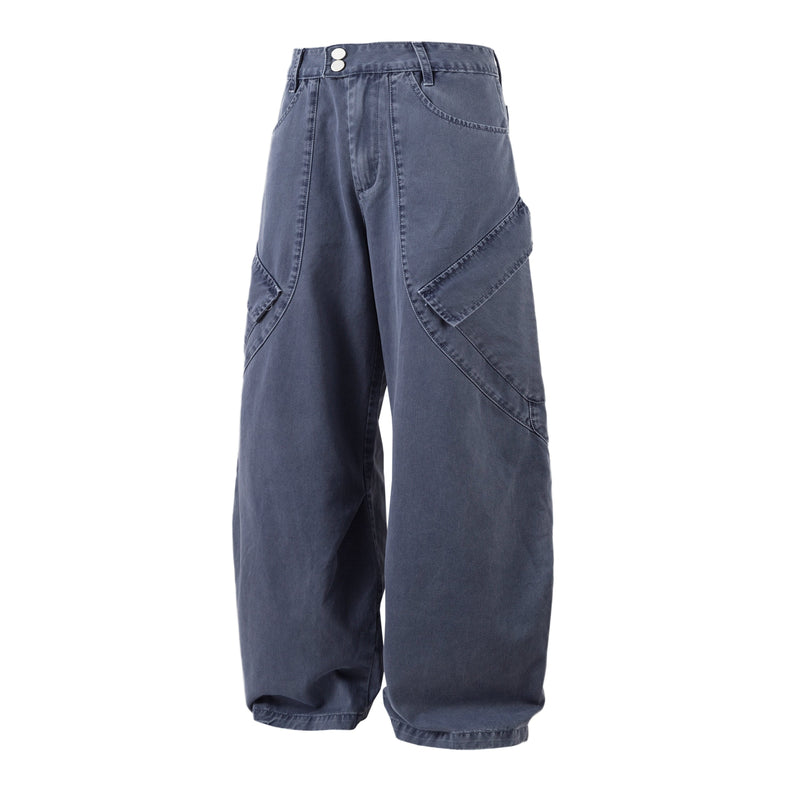 Front angled view of blue barrel-leg denim pants with curved seams and wide legs