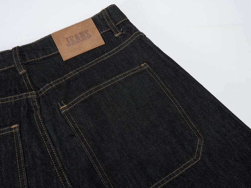 Close-up of back waistband label and topstitching on dark wash carpenter jeans