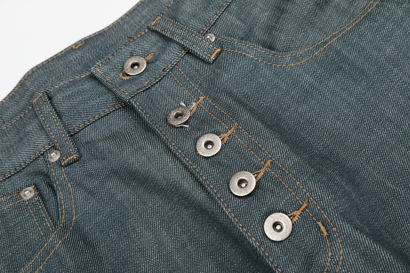 Close-up of the button-fly front on washed grey denim with tan topstitching
