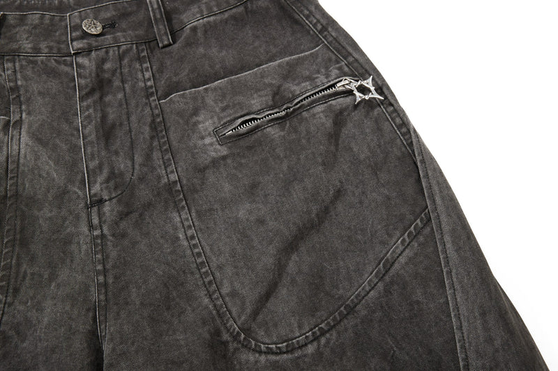 Dark charcoal denim front pocket close-up with curved seam and zipper detail