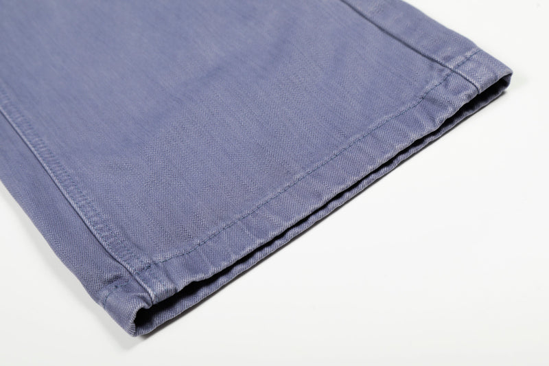 Close-up of the cuffed hem on blue wide-leg denim carpenter pants