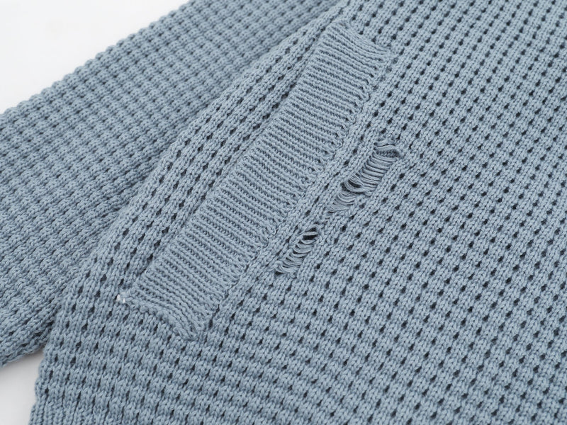 Close-up of light blue cardigan sleeve and shoulder with distressed knit detail