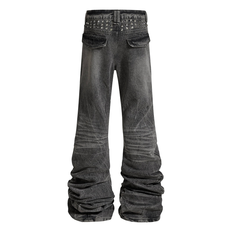 Back view of gray-black jeans with studded waistband and flap back pockets