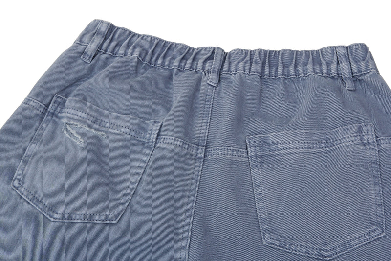 Close-up of the back waistband and pockets on blue baggy jeans