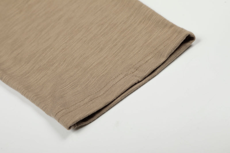 Folded brown long sleeve tee showing sleeve hem and soft ribbed knit texture