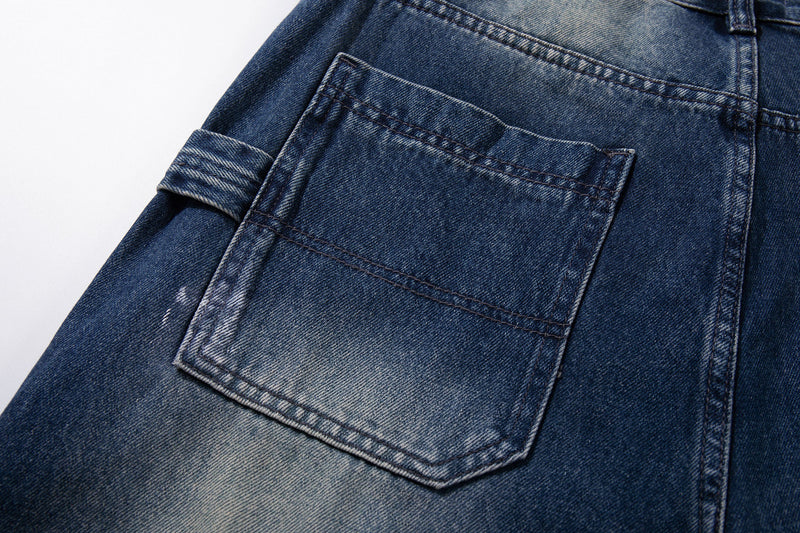 Close-up of side cargo pocket on faded dark blue denim jeans