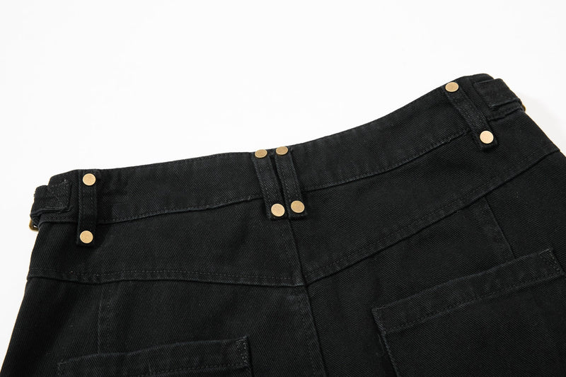 Close-up of black pants waistband and side seam with gold snap details