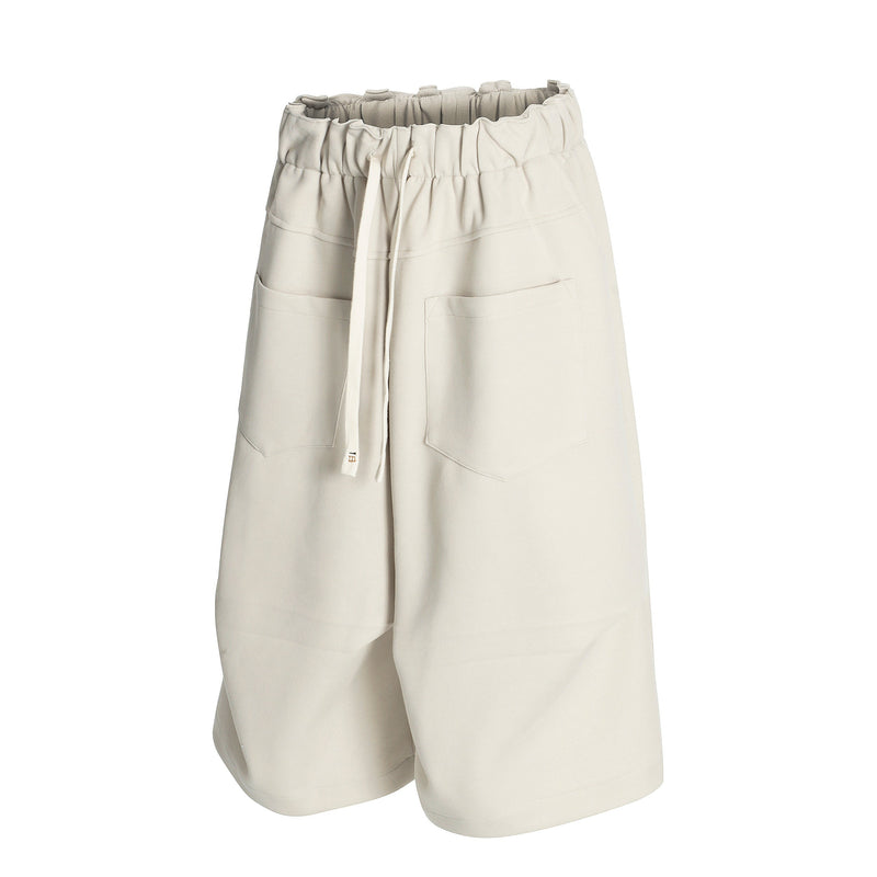 Cream wide-leg shorts front view with drawstring and side patch pockets