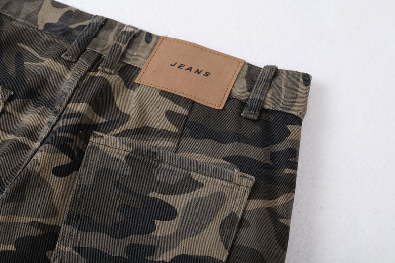 Close-up of waistband and front pocket on camo cargo pants with tan JEANS label