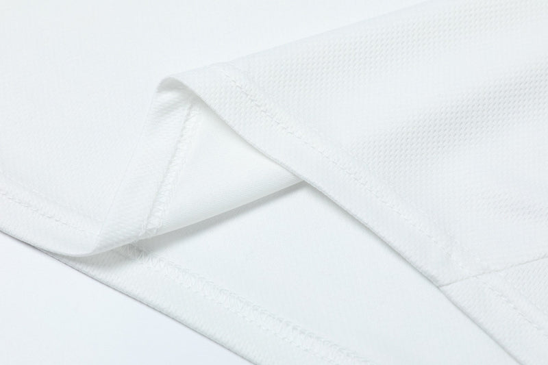 Close-up of white athletic jersey fabric with clean stitched hem and breathable mesh texture