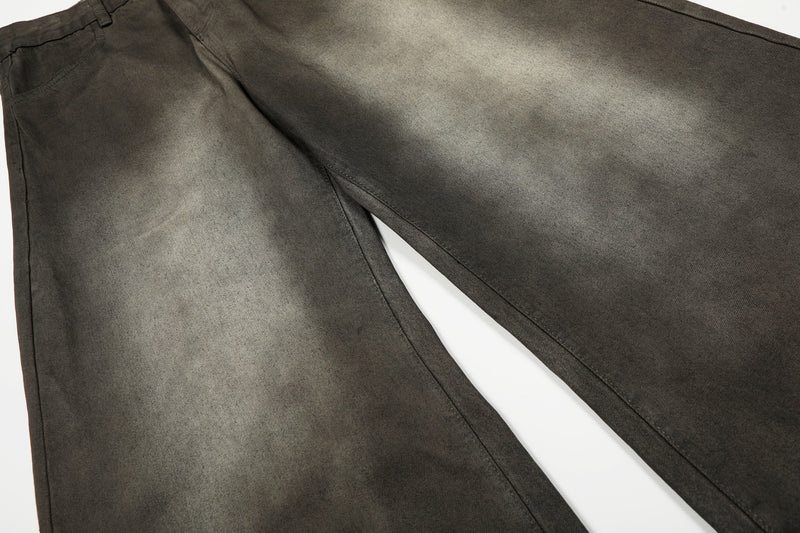 Pair of faded black curved wide-leg denim pants laid flat, showing the legs and wash