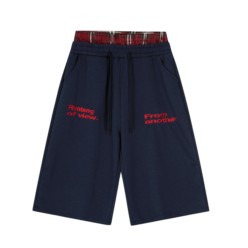 Navy streetwear shorts with red plaid waistband and red embroidered front text