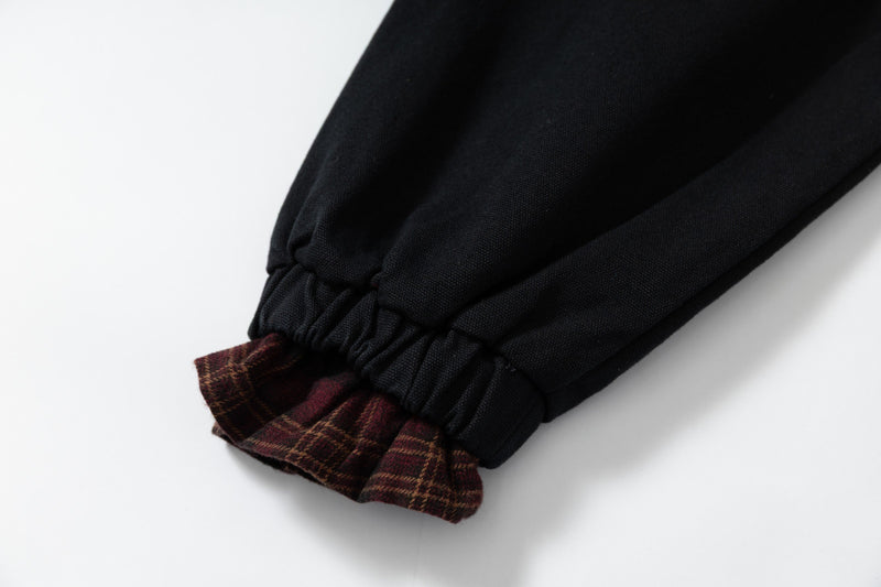 Close-up of black elastic sleeve cuff with plaid lining underneath