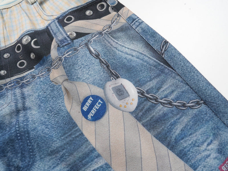 Close-up of the right leg with chain print, tie graphic and blue badge detail