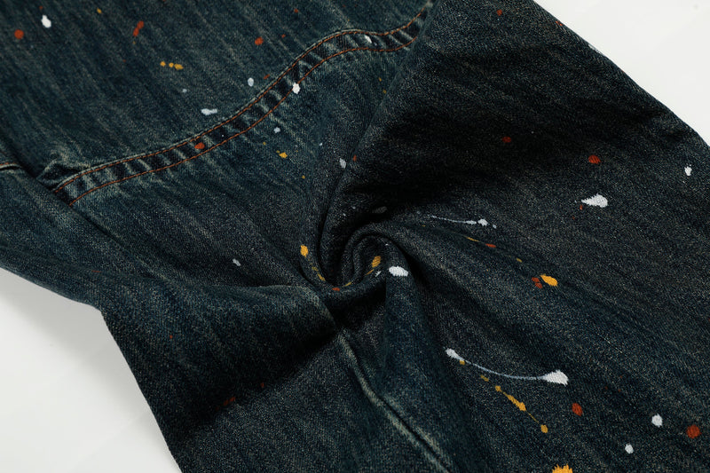 Paint-splattered dark wash denim gathered at the knee with patchwork seam detail