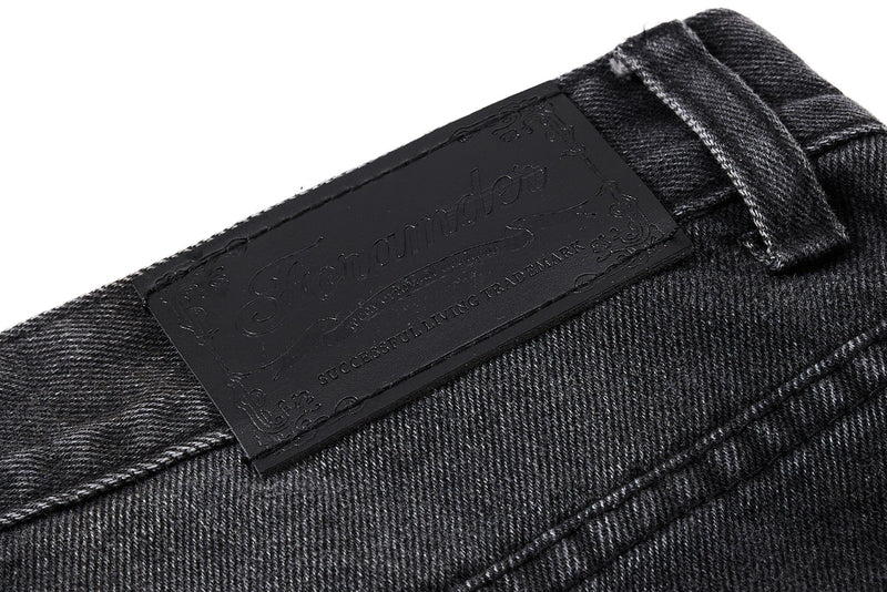 Close-up of black waistband leather patch with embossed text
