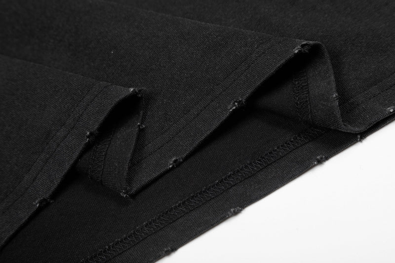 Close-up of black graphic tee hem with distressed raw edges and stitched seams for punk streetwear style
