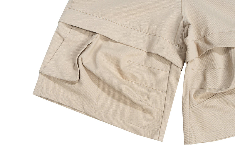 Close-up of beige shorts layered leg pocket and hem detail