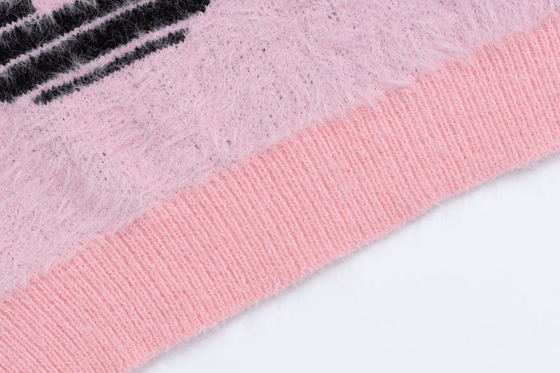 Close-up of pink ribbed sweater hem and fuzzy knit body with black stripe detail