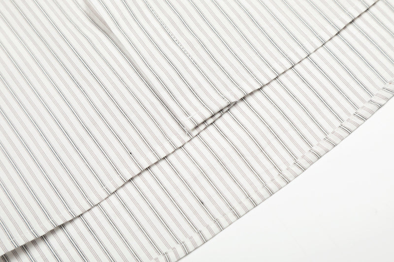 Close-up of folded cream shirt fabric with thin vertical stripes
