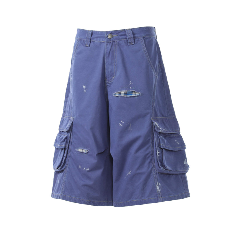 Blue cargo shorts front view with plaid patch at ripped opening and side flap pockets
