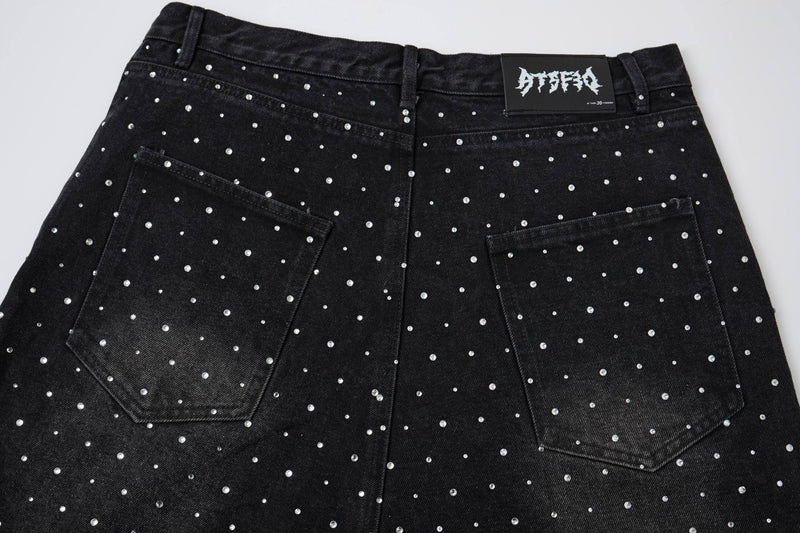 Front waistband and pockets of black denim shorts with pearl studs