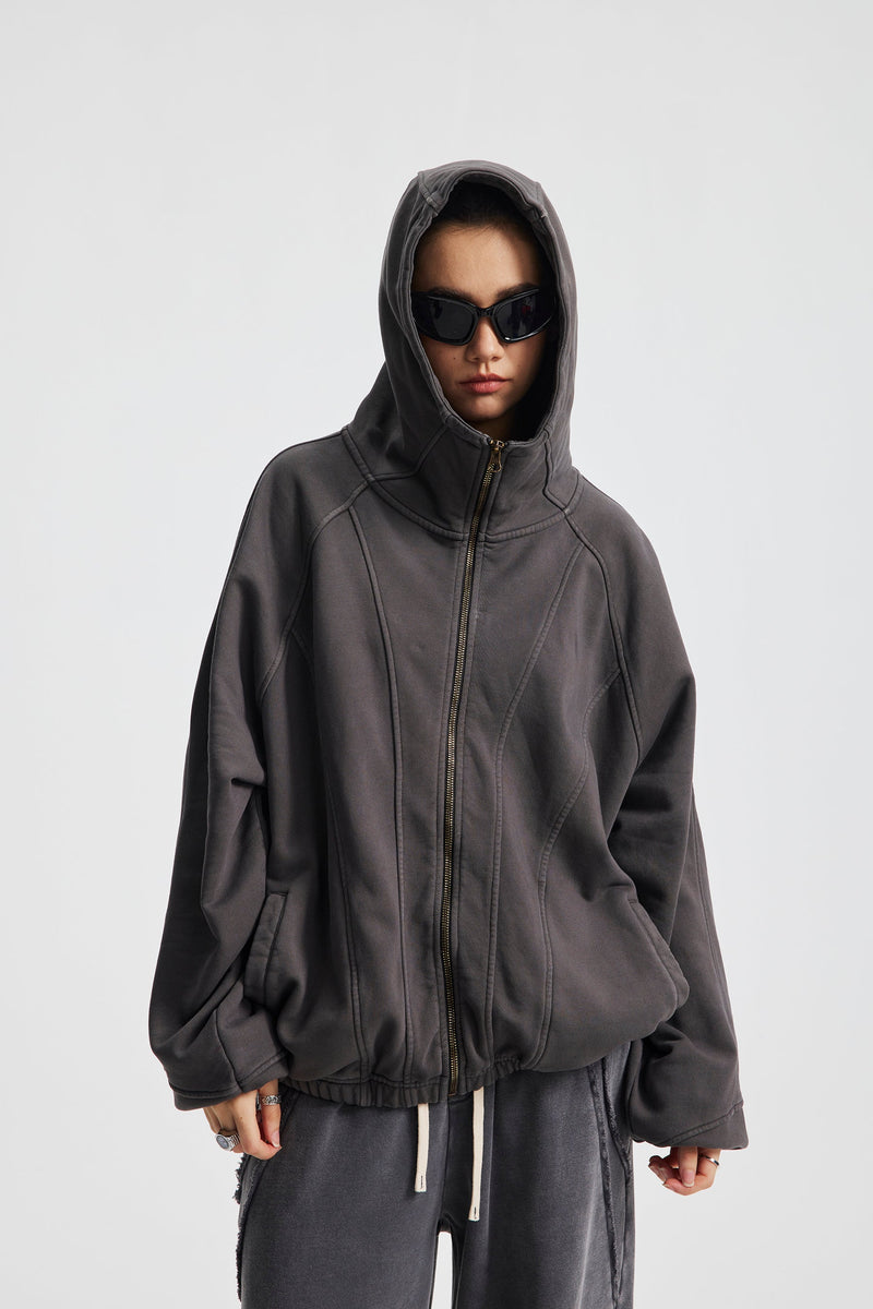 Model wearing charcoal gray full-zip hoodie with hood up and black sunglasses