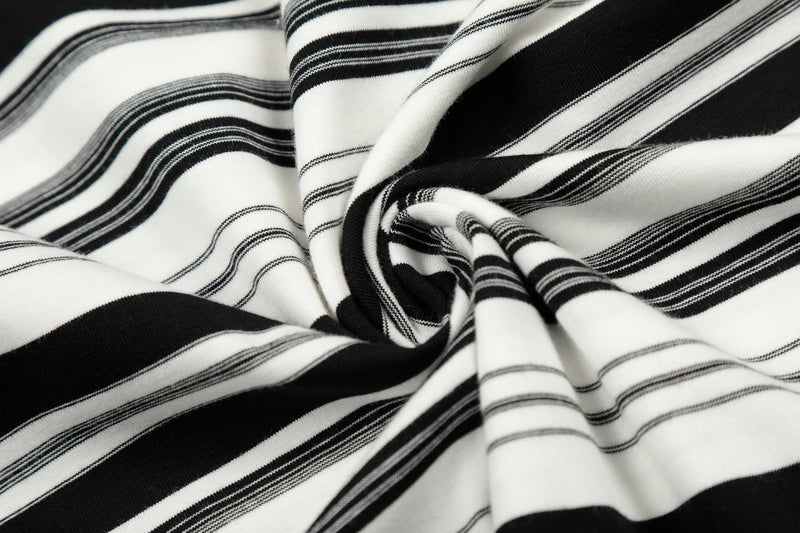 Close-up of black and white striped fabric gathered into folds, showing texture and stripe pattern