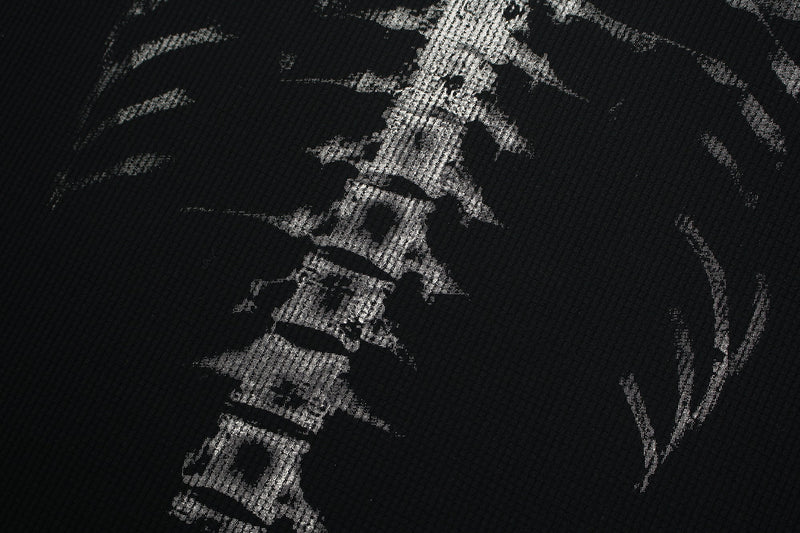 Black streetwear tee with distressed white ribcage skeleton graphic print on textured fabric close-up