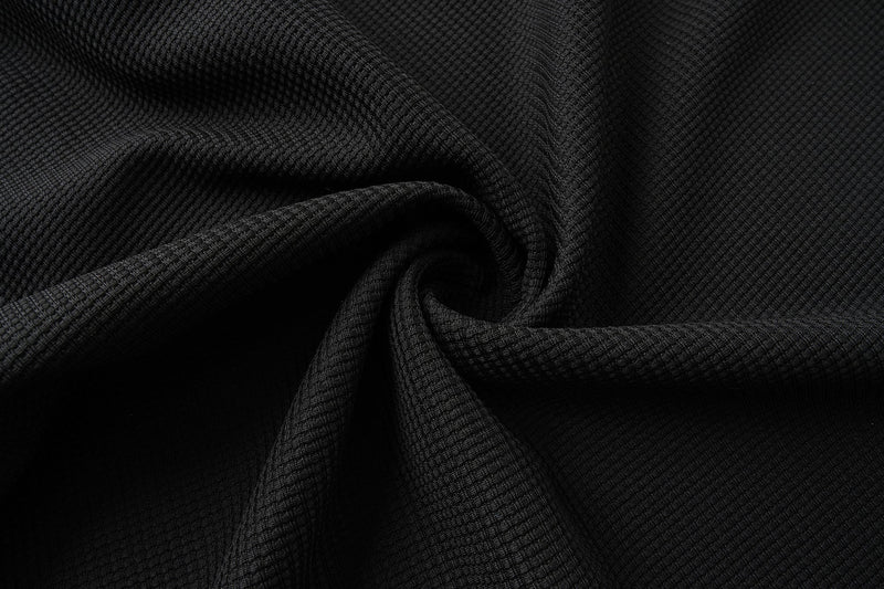 Black waffle-knit fabric draped in folds with textured knit detail
