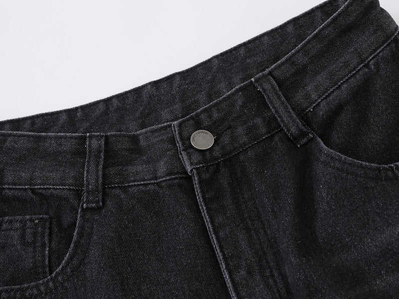 Close-up of black denim waistband with button and belt loops