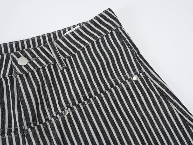 Close-up of striped jeans front waist with button, pocket edge, and topstitching