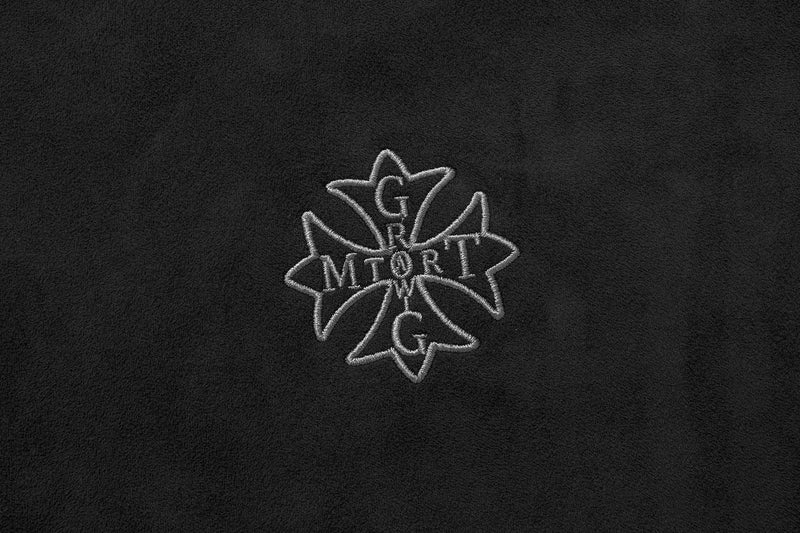 Close-up of embroidered chest logo on black suede hoodie