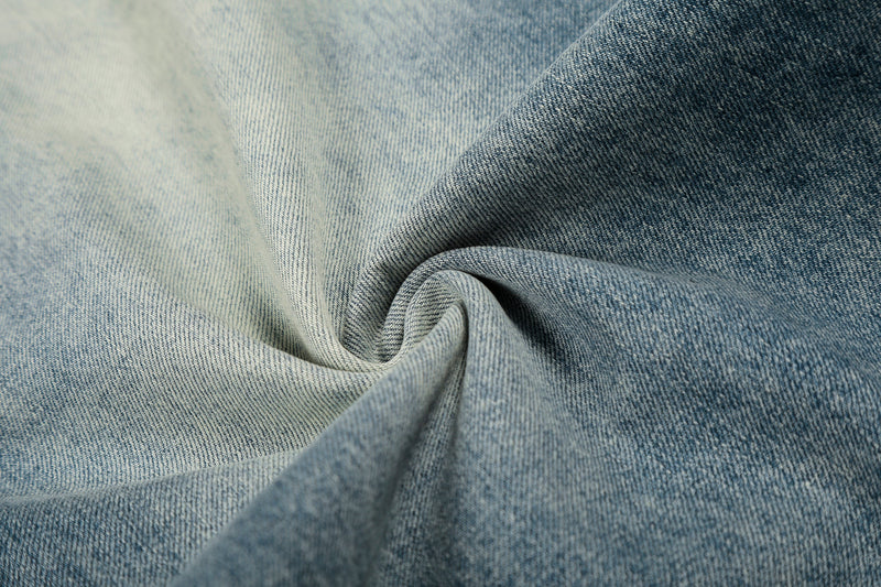 Close-up of light and dark blue denim fabric swirl showing soft twill texture