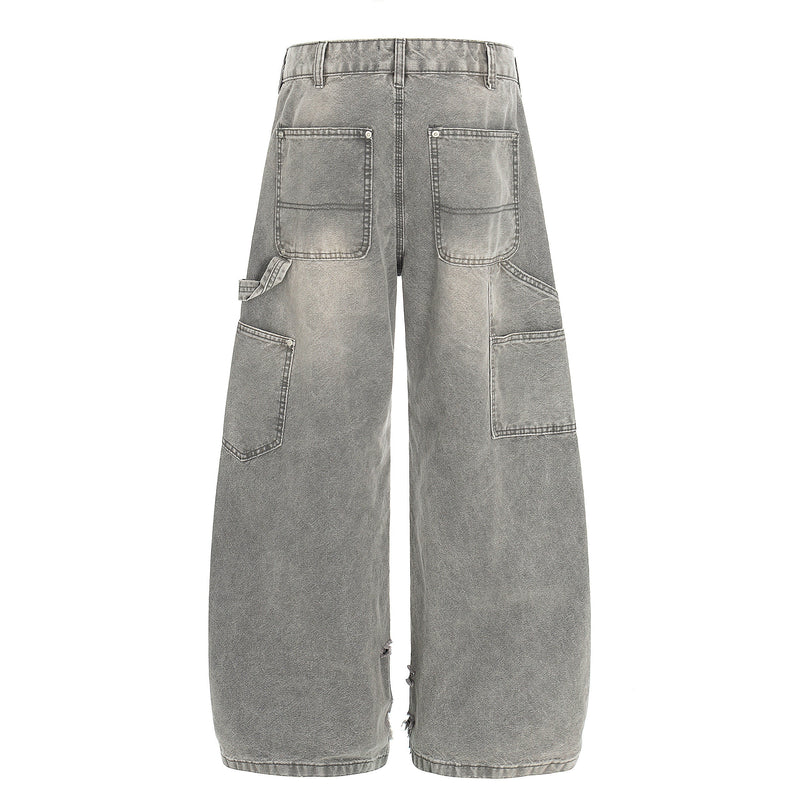 Back view of gray washed carpenter jeans with patch pockets and distressed hem