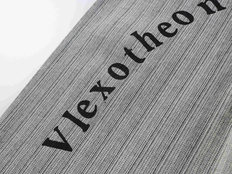 Diagonal close-up of black printed lettering on gray textured pants