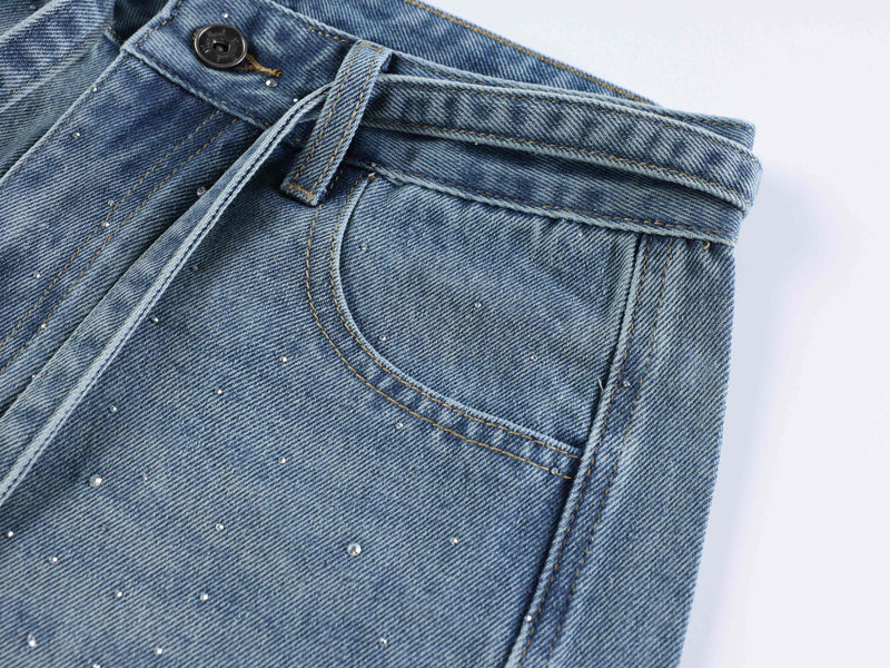 Light blue front pocket close-up with belt loop and rhinestone details