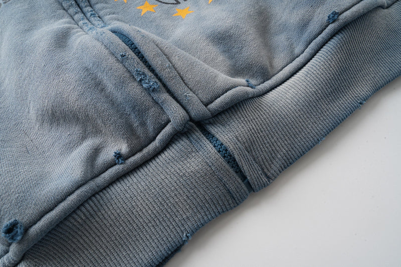 Close-up of lower front zipper and hem with ribbed trim on blue hoodie