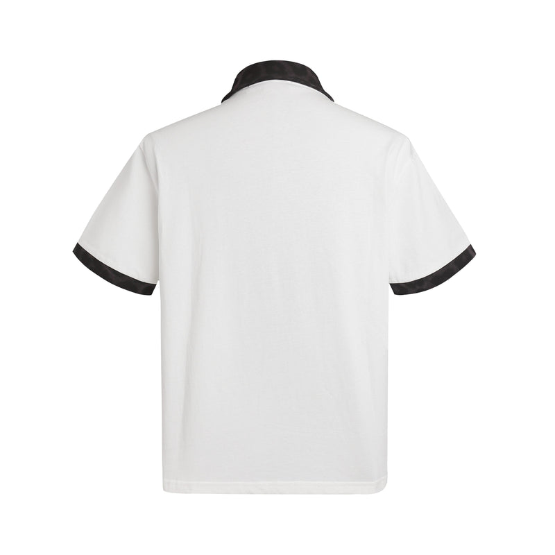 White polo shirt with black leopard-print collar and sleeve trim, shown from the back on a clean white background