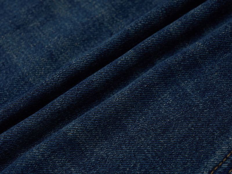 Close-up of dark blue denim fabric with visible diagonal weave texture