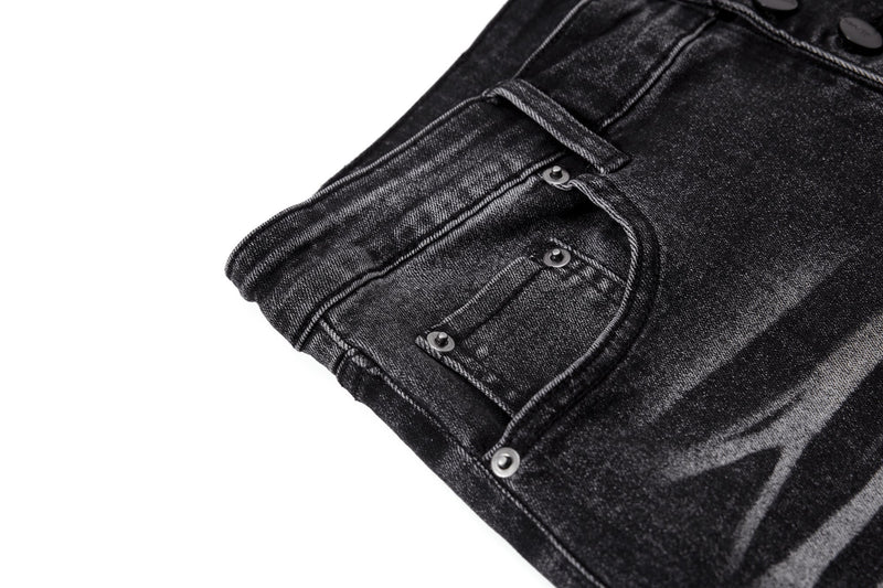 Close-up of black denim back pocket with rivets and washed finish