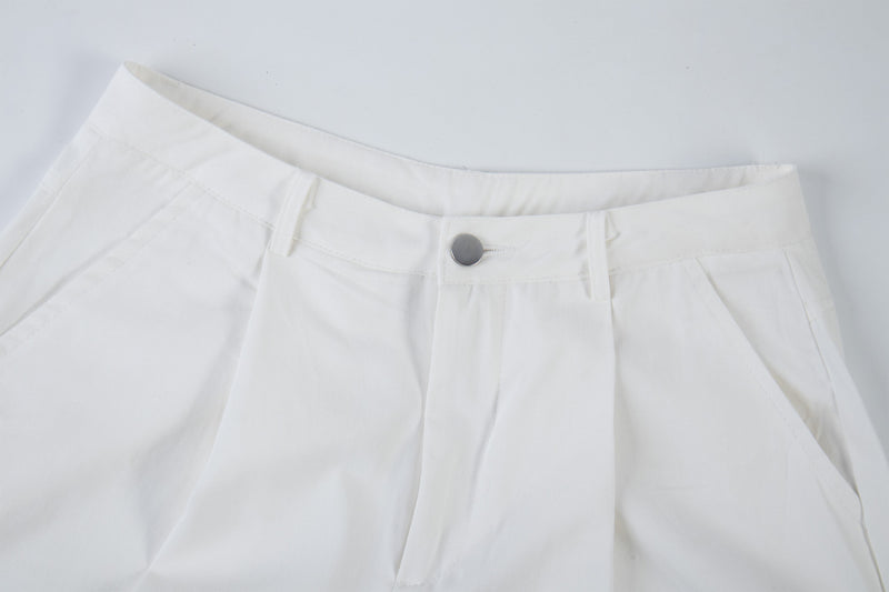 Close-up of white cargo pants waistband with silver snap button and belt loops