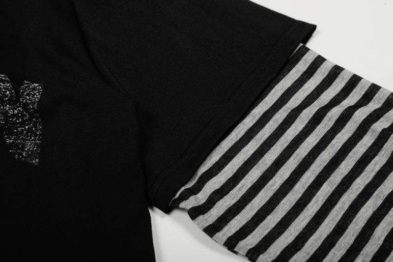 Close-up of black sleeve with gray horizontal stripes and shoulder seam