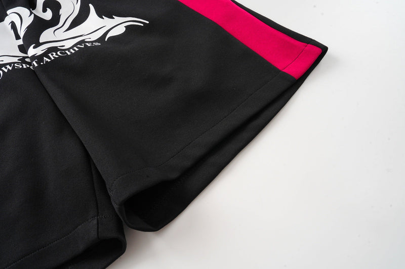 Close-up of black leg opening with magenta side stripe and stitched hem
