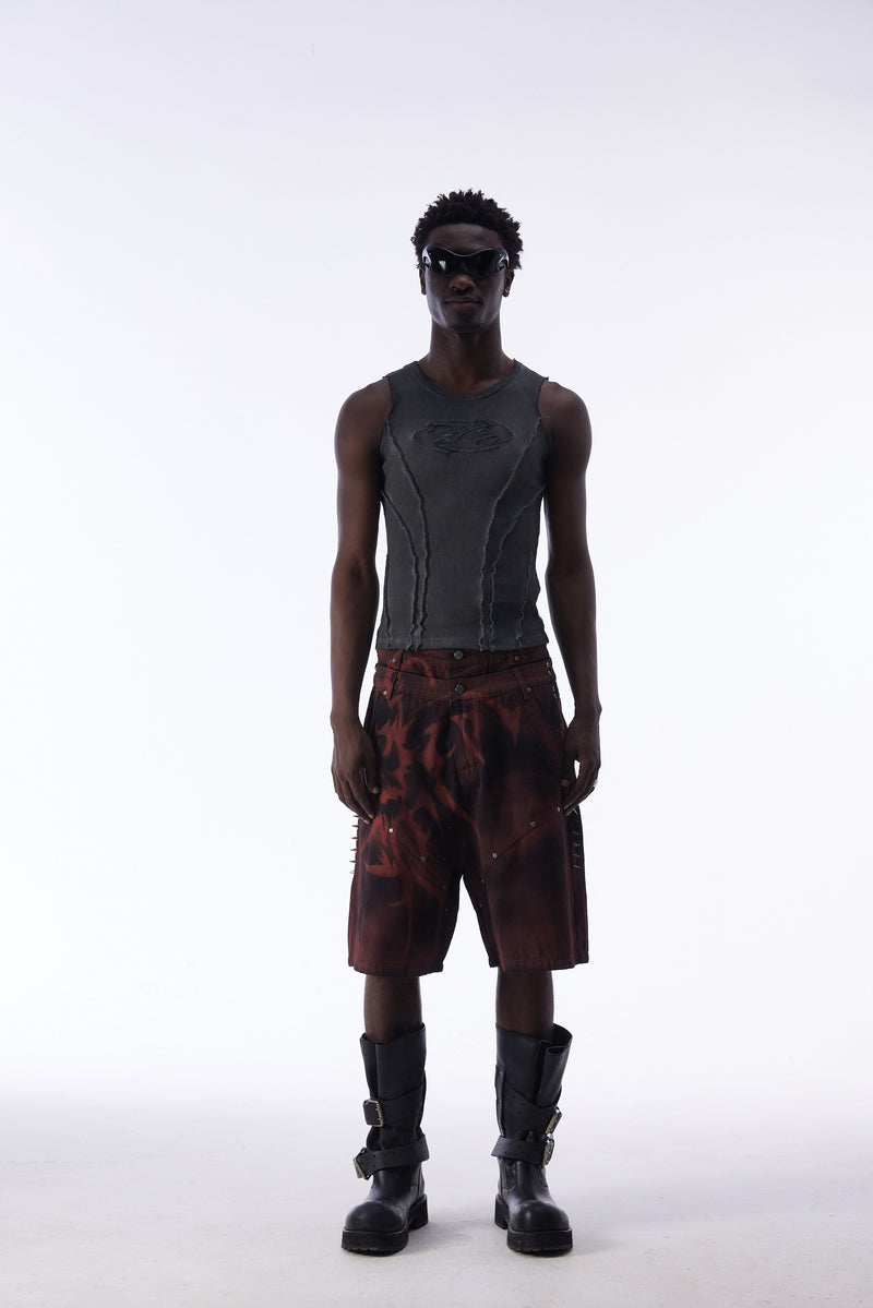 Front view of model wearing burgundy tribal jorts and gray ribbed tank top