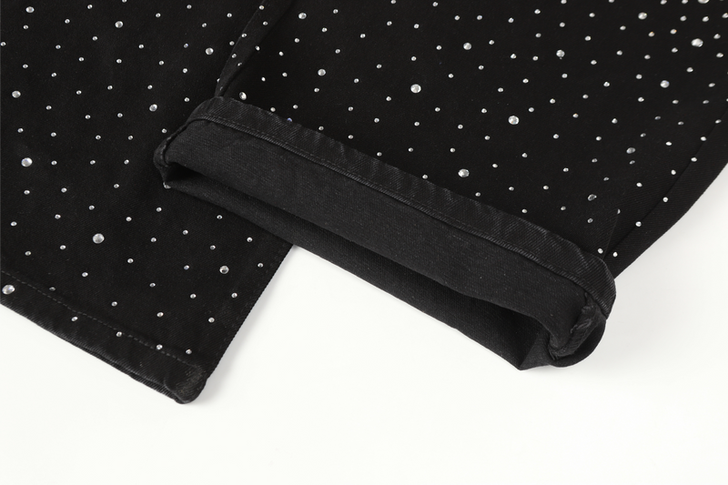 Cuffed hem of black rhinestone jeans, close-up