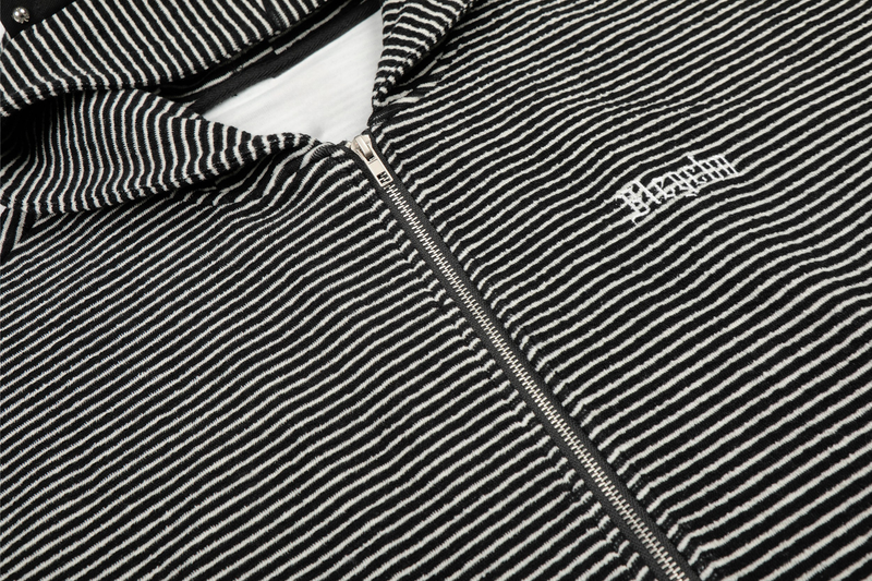 Close-up of black striped zip front and chest logo