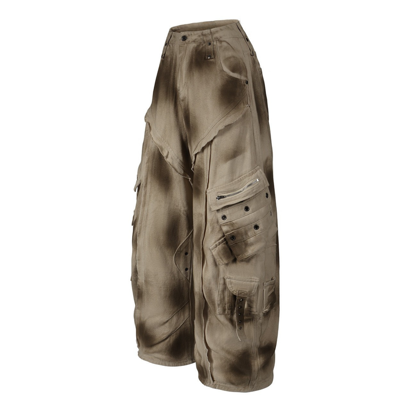 Angled front view of beige distressed cargo barrel pants with side flap pockets and paint-like dark marks