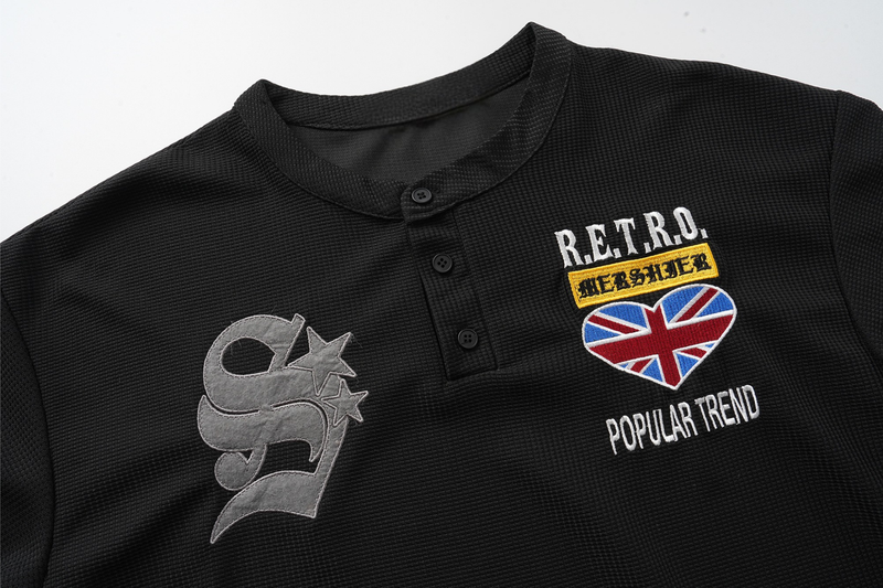 Front upper chest close-up of black waffle-knit Henley with retro patches and Union Jack heart